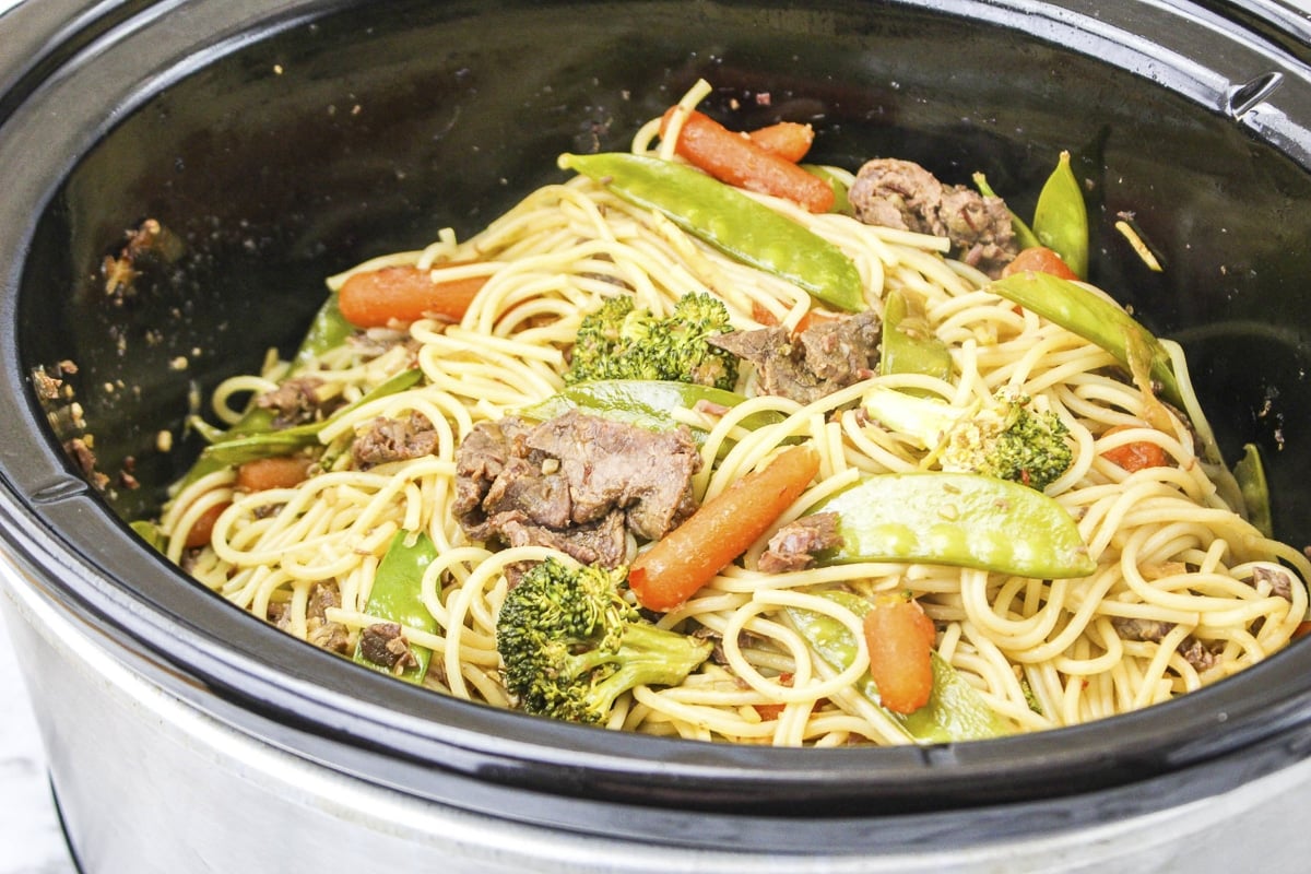 Close up of chow mein with beef, carrots and snow peas