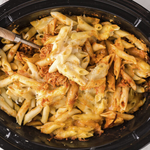 cooked penne pasta with chicken, cheese and sauce in slow cooker