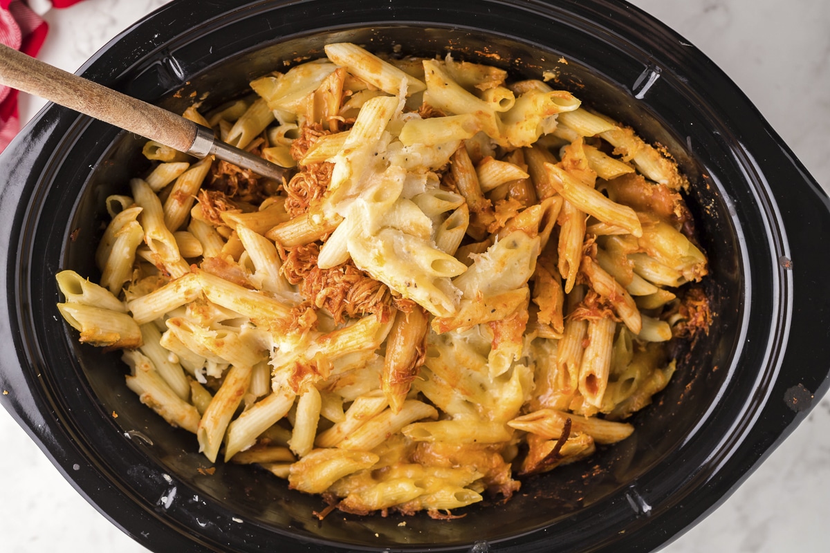 cooked penne pasta with chicken, cheese and sauce in slow cooker