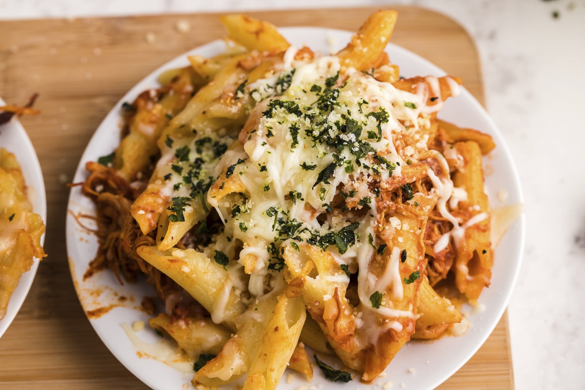 close up plate of chicken parmesan penne pasta