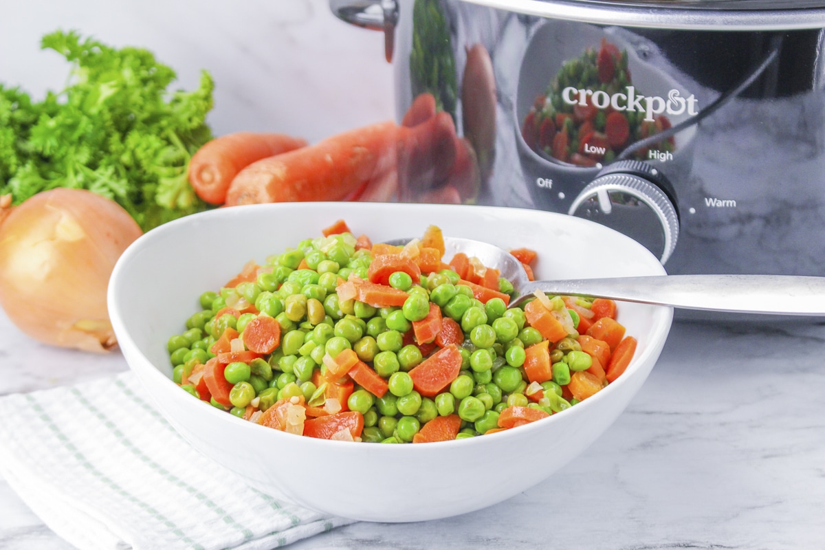 bowl of peas and carrots in front of slow cooker