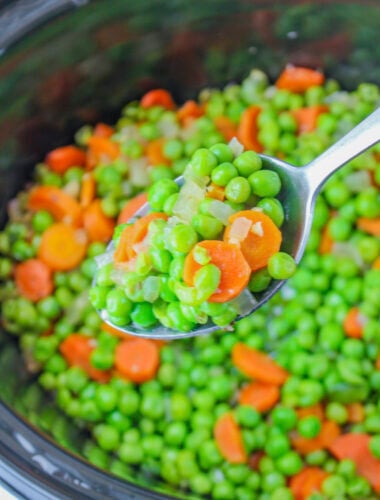 slow cooker peas and carrots on a metal spoon