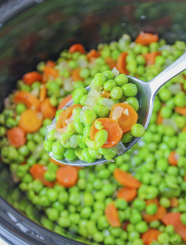 slow cooker peas and carrots on a metal spoon