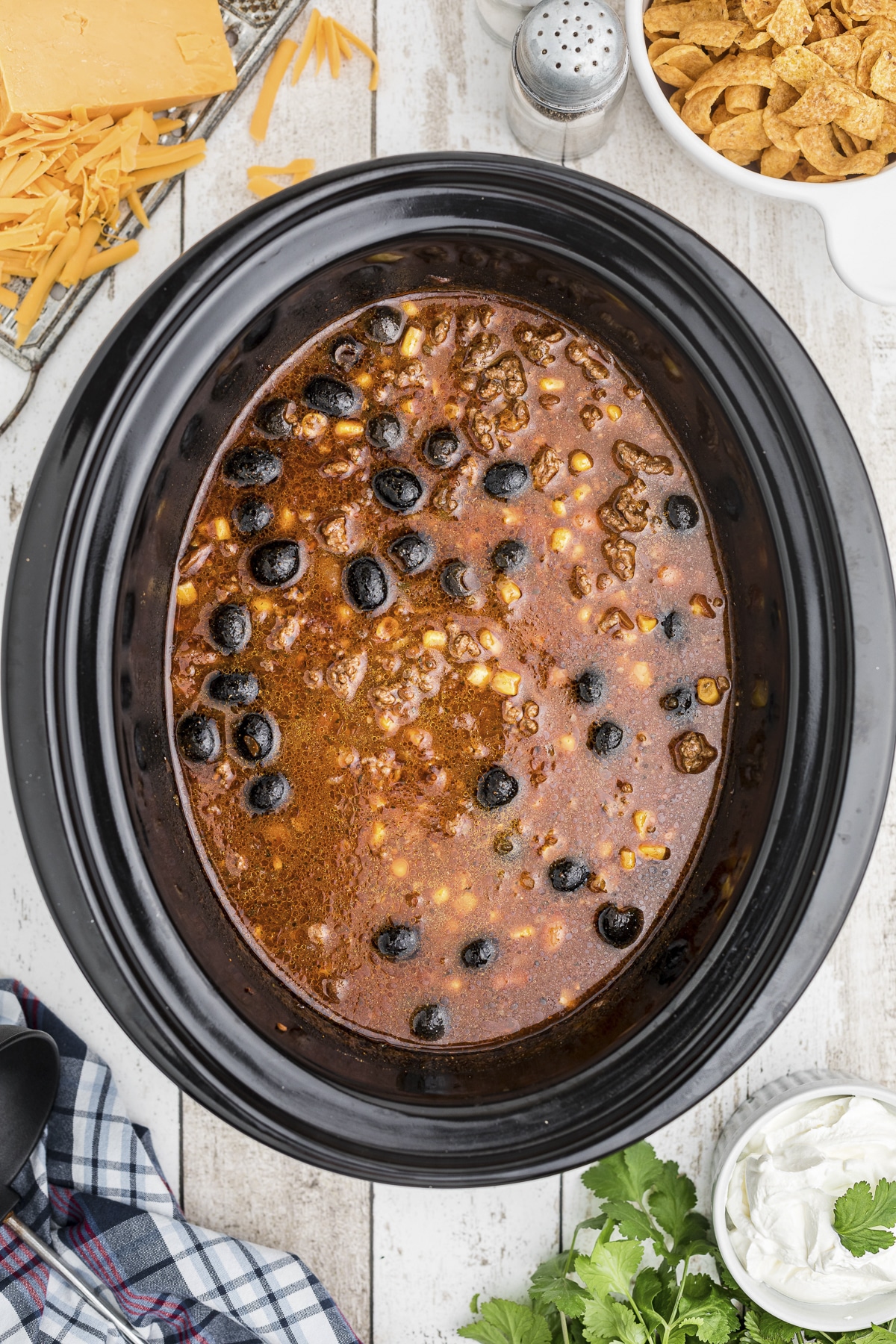 Taco soup in slow cooker with whole black olives
