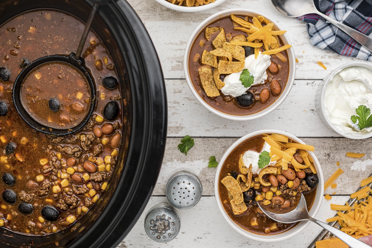 overhead shot of taco soup in slow cooker and bowls
