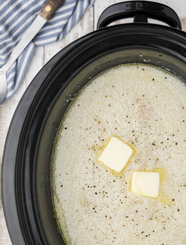 Grits cooked in a slow cooker with butter pats