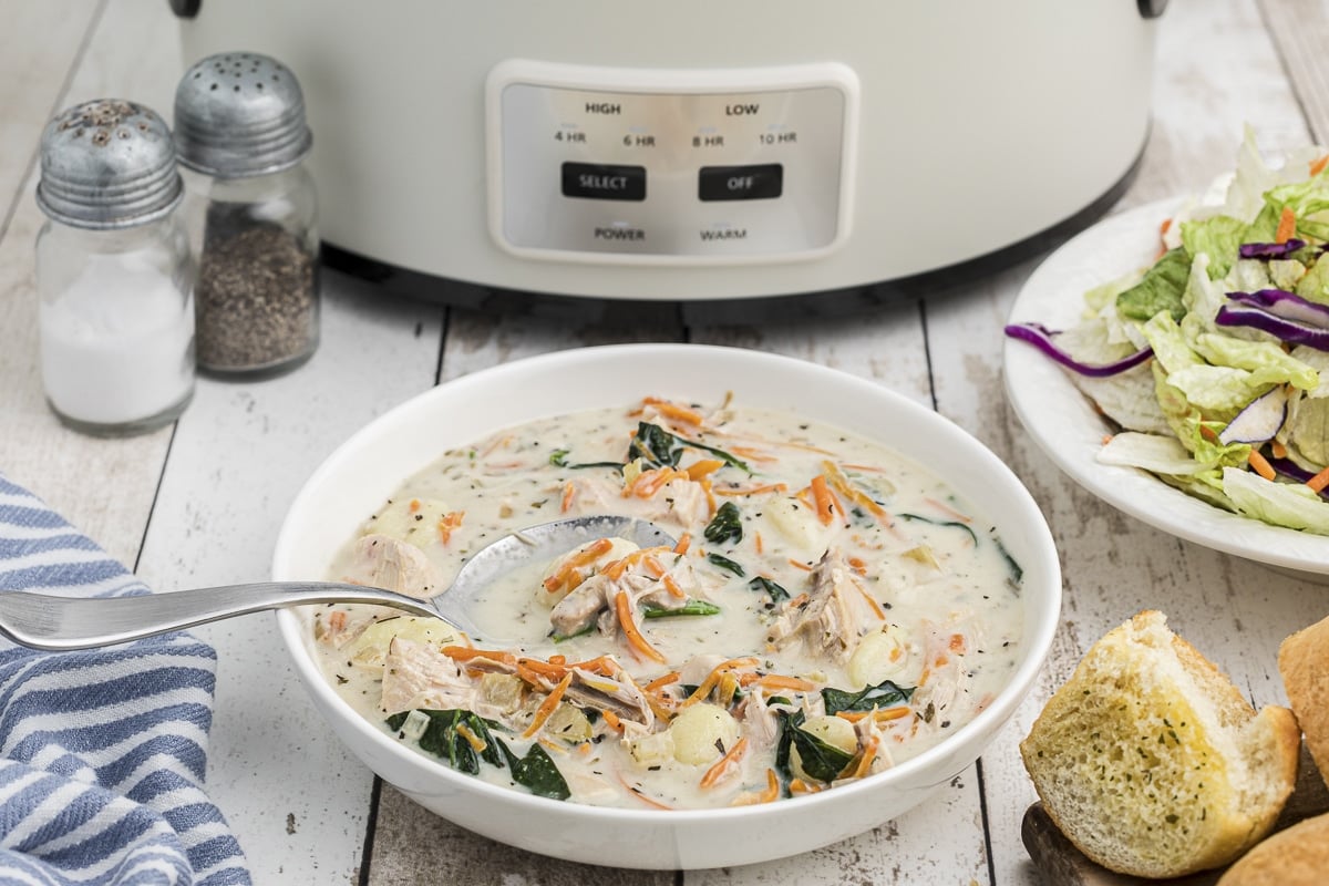 bowl of gnocchi soup in front of slow cooker