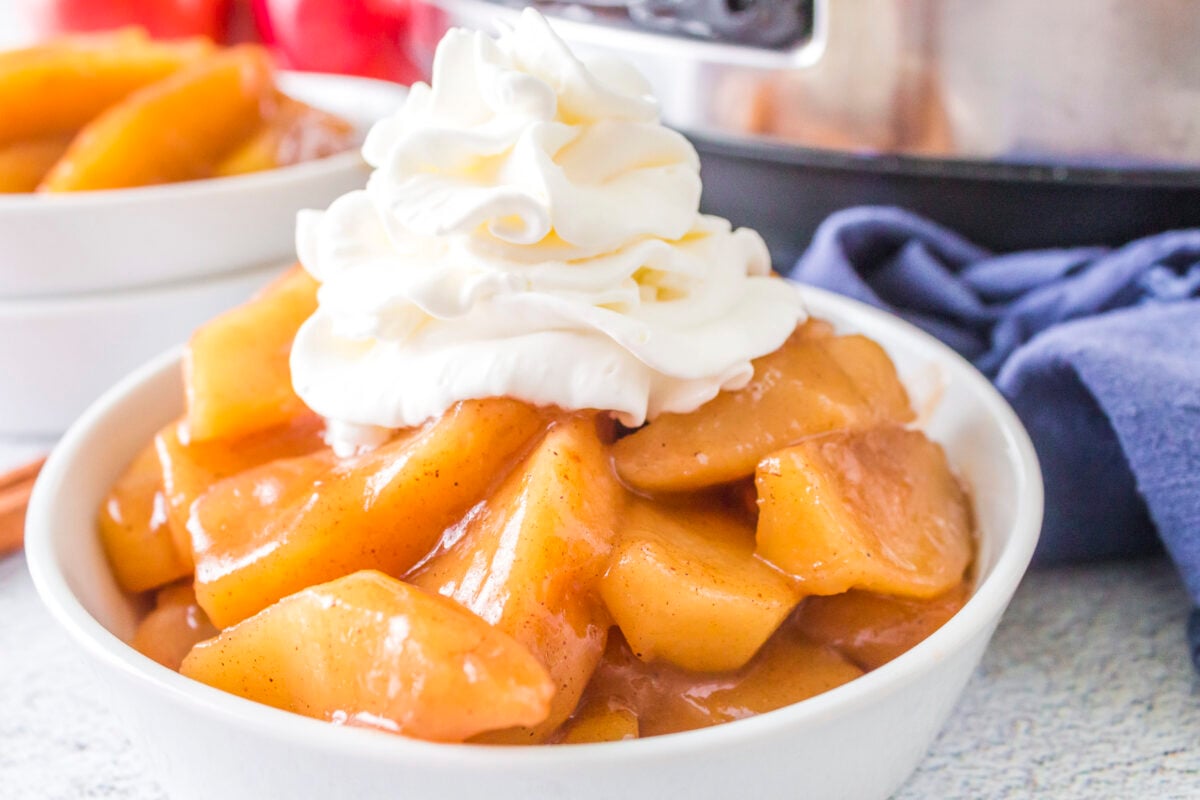 bowl of fried apples with whipped cream on top
