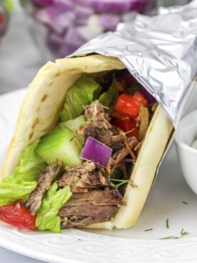 slow cooker gyros with sauce on side.