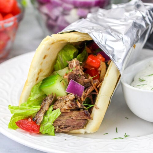 slow cooker gyros with sauce on side.