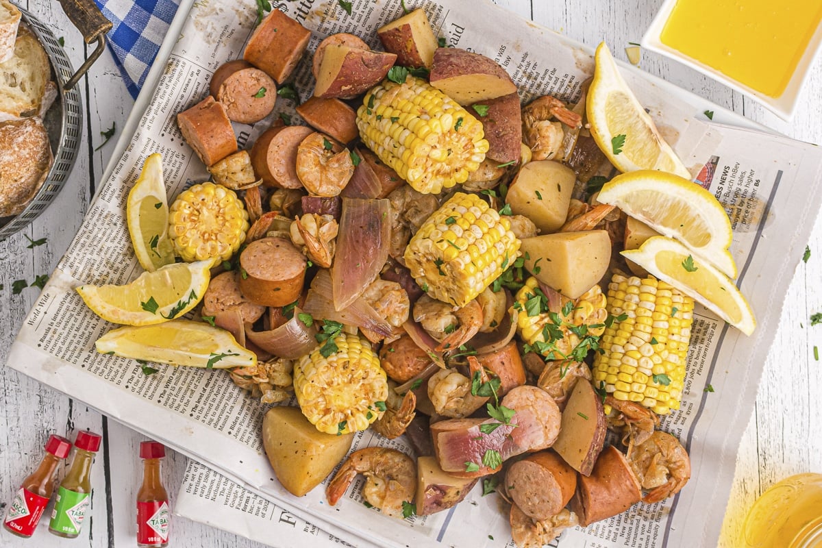 shrimp boil contents on newspaper with lemon.