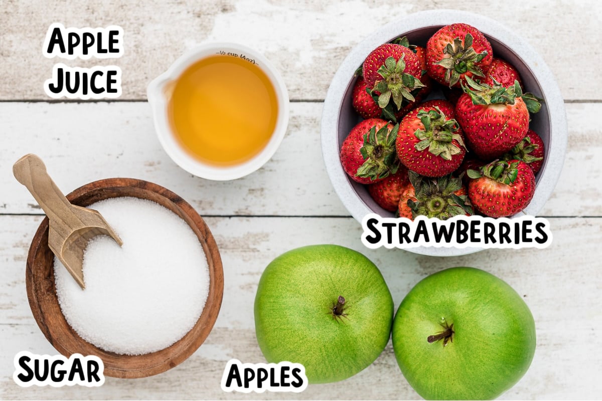 Ingredients for strawberry applesauce on table.