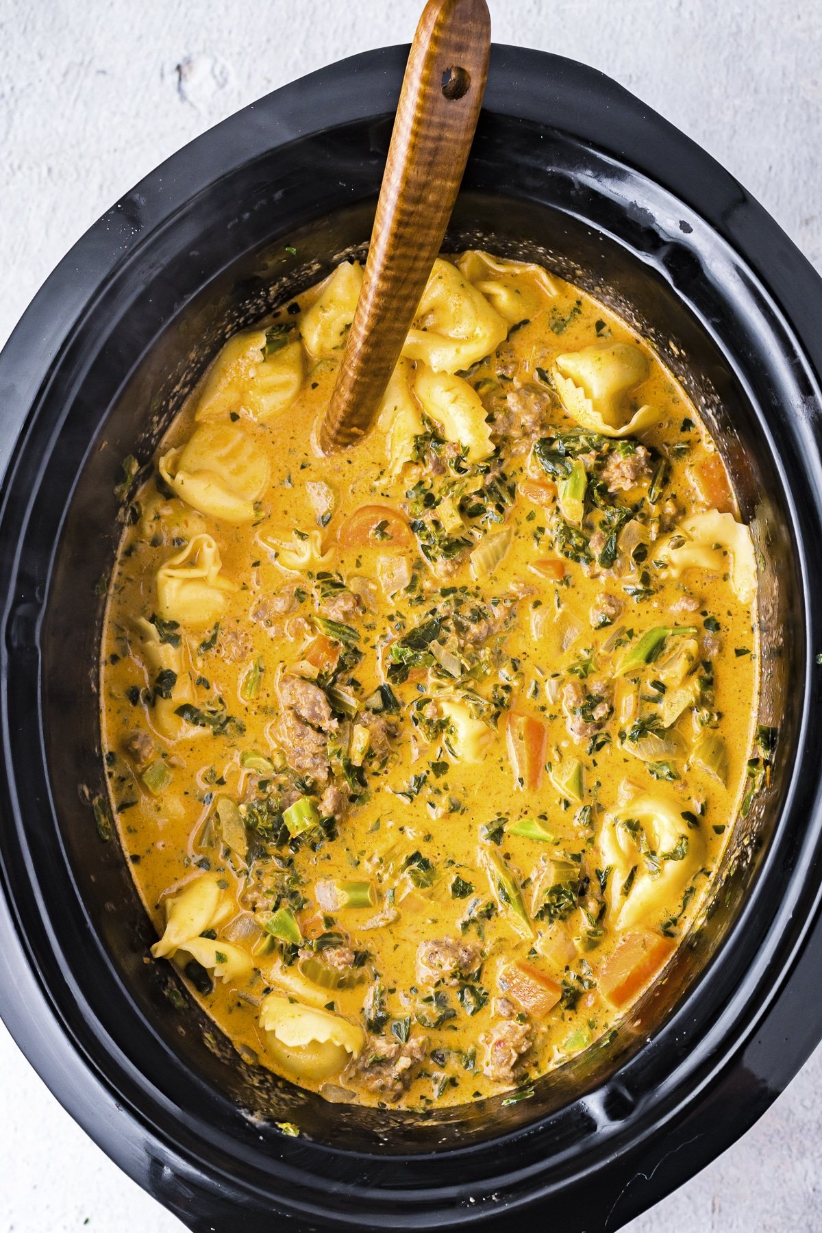 close up of tortellini soup done cooking in crockpot