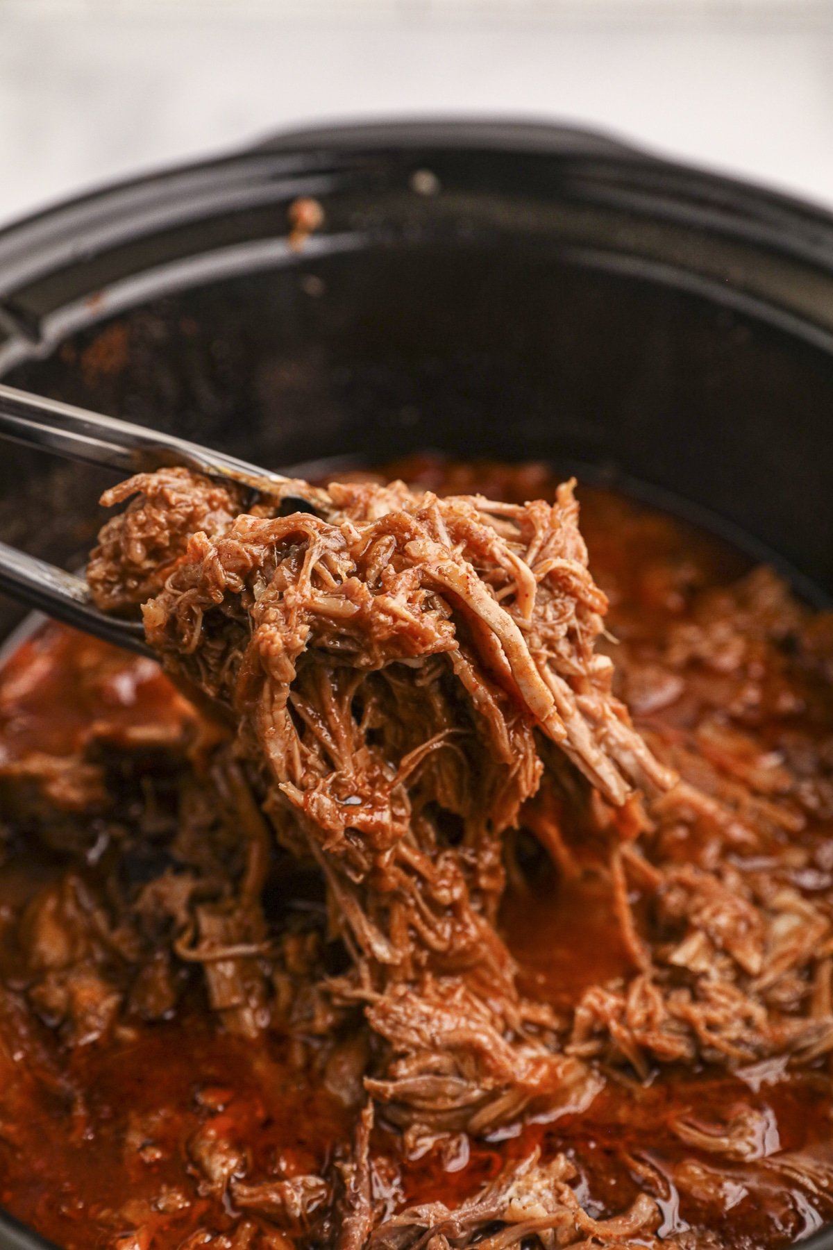 beer pulled pork, shredded on tongs.