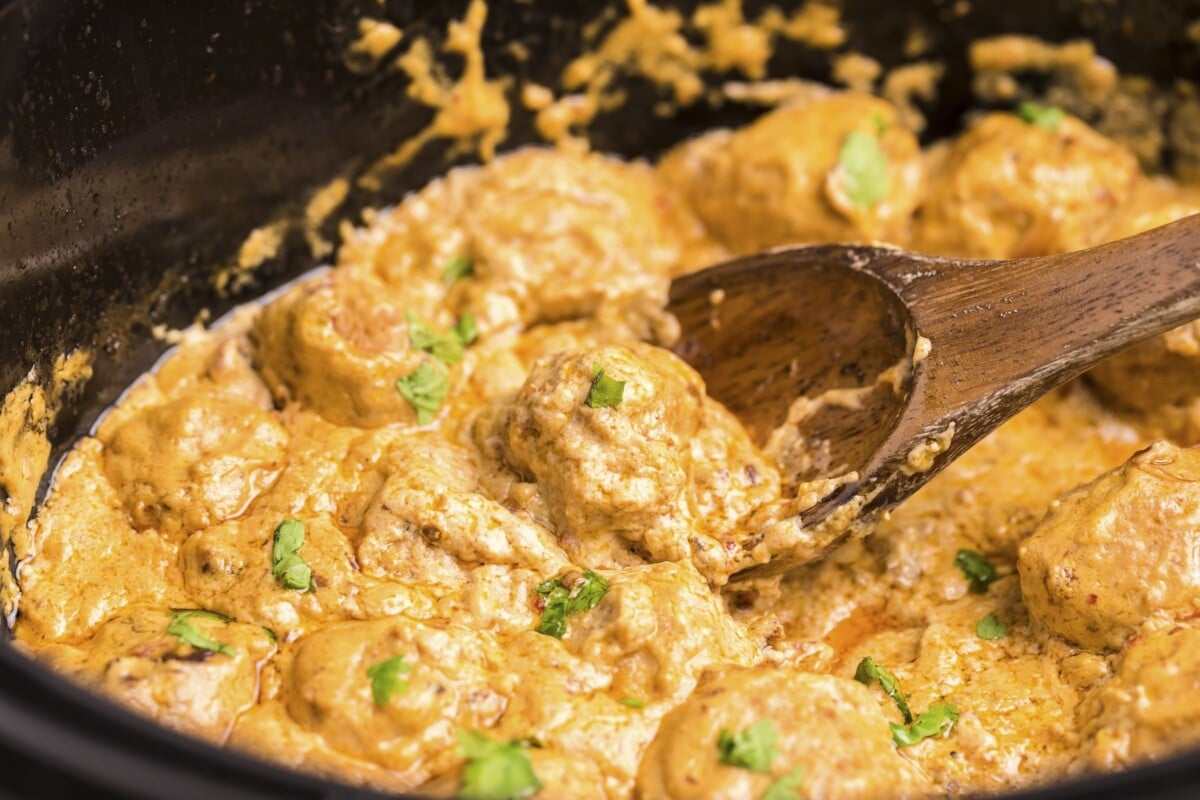 close up of creamy chipotle chicken meatballs with spoon in them.