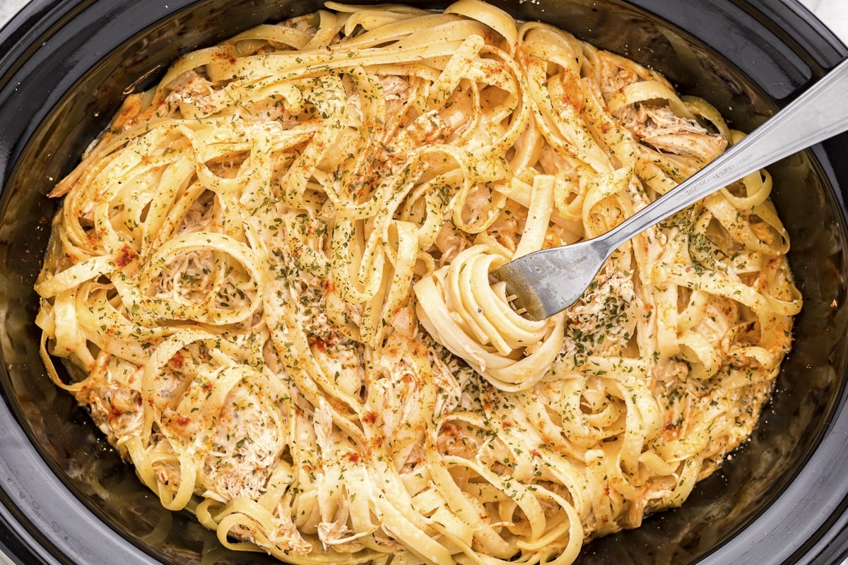 Fork in cajun chicken fettuccine in slow cooker.