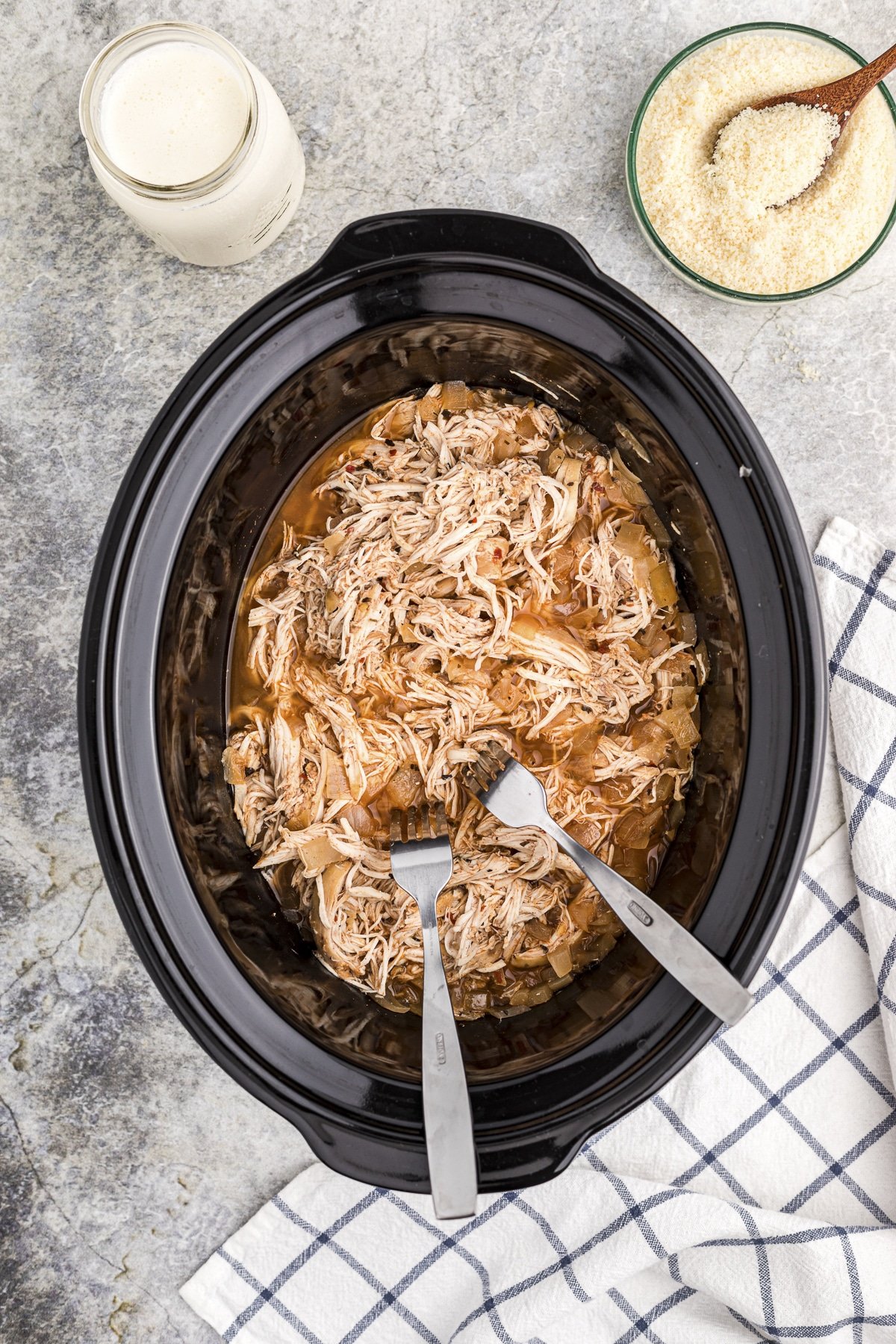 2 forks shredding chicken in the crockpot.
