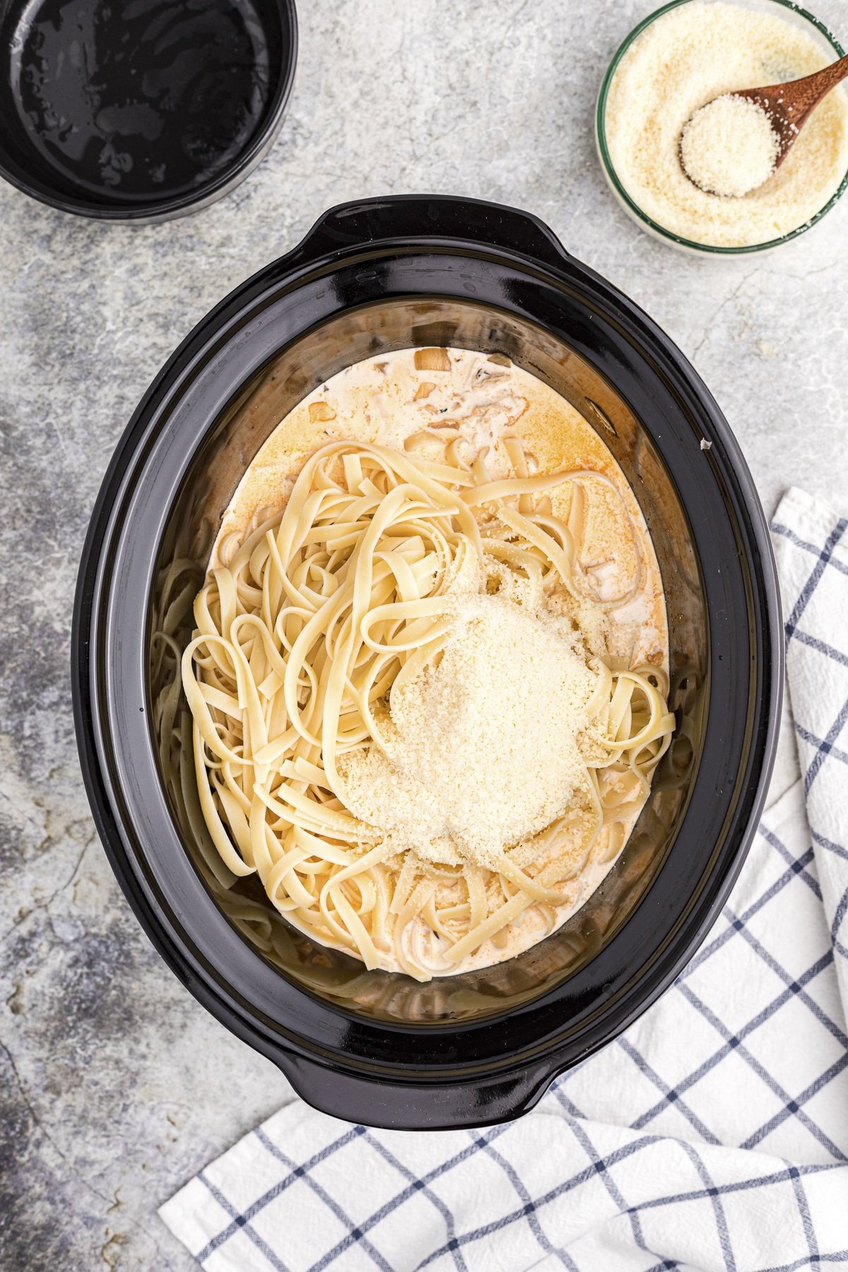 cream, parmesan, and fettuccine added to the slow cooker to make cajun alfredo.
