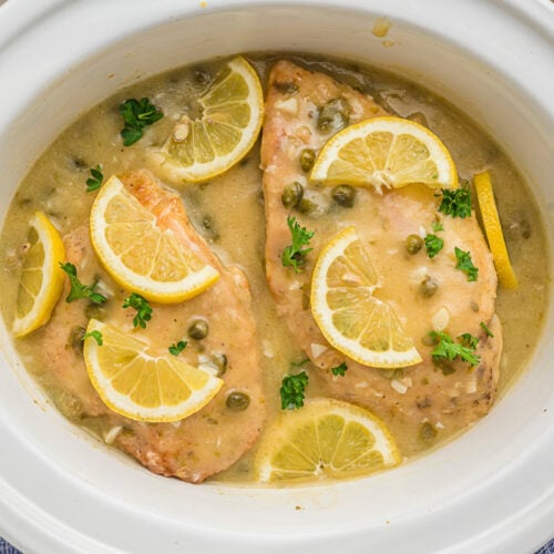 cooked chicken piccata with lemon slices.