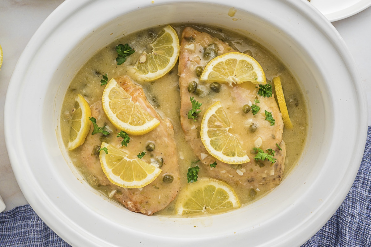 cooked chicken piccata with lemon slices.