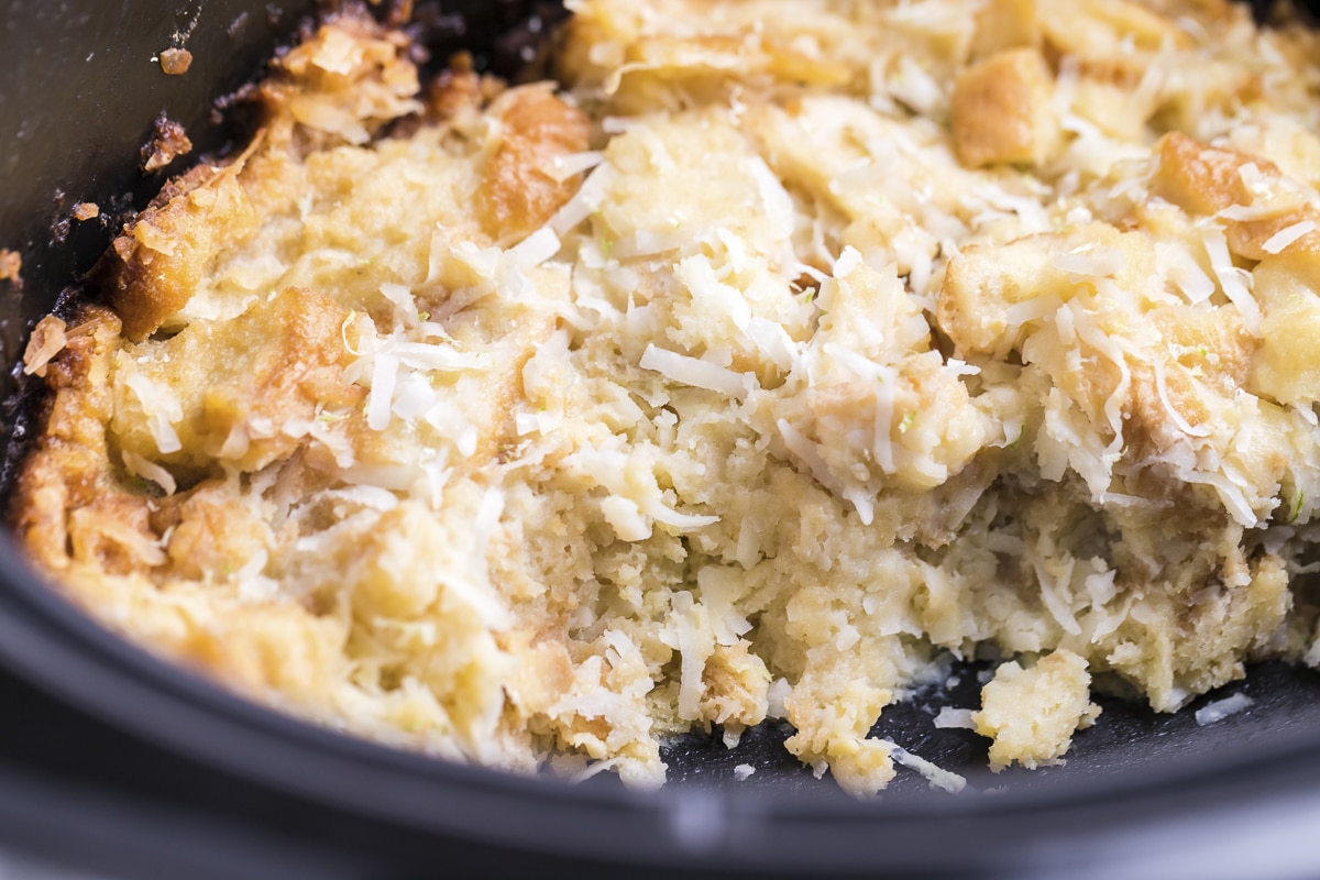 coconut bread pudding with scoop out of it.