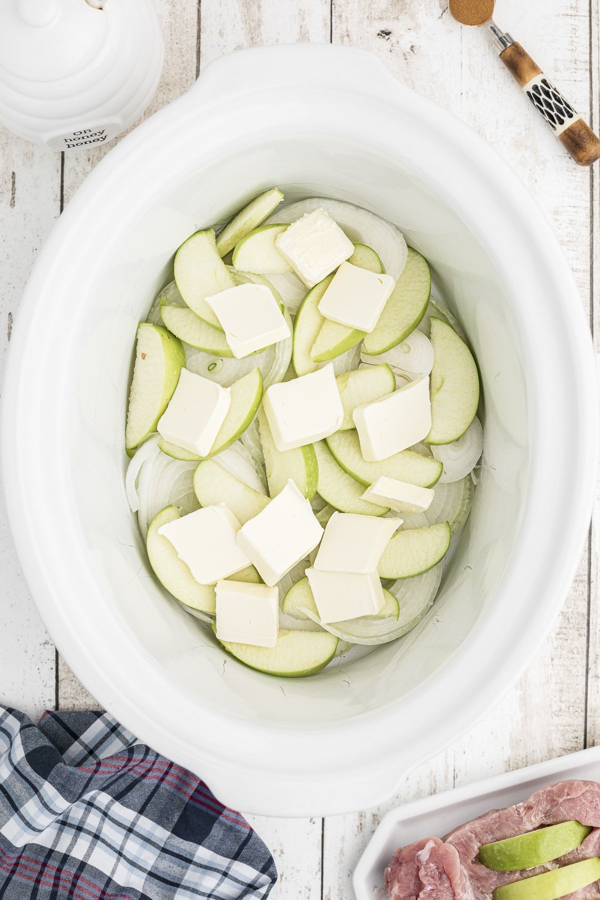 Apples and butter in a slow cooker.
