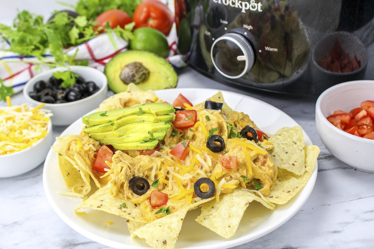 Shredded queso chicken on top of chips to make nachos.