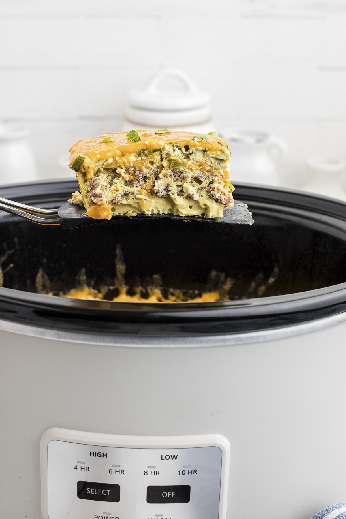 square of sausage green chile egg casserole on spatula.