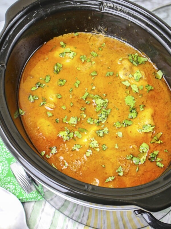 Thai peanut chicken in slow cooker with cilantro on top.