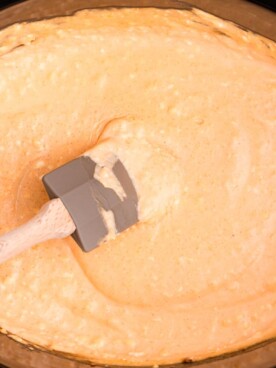 very close up of beer cheese dip with spoon in it.