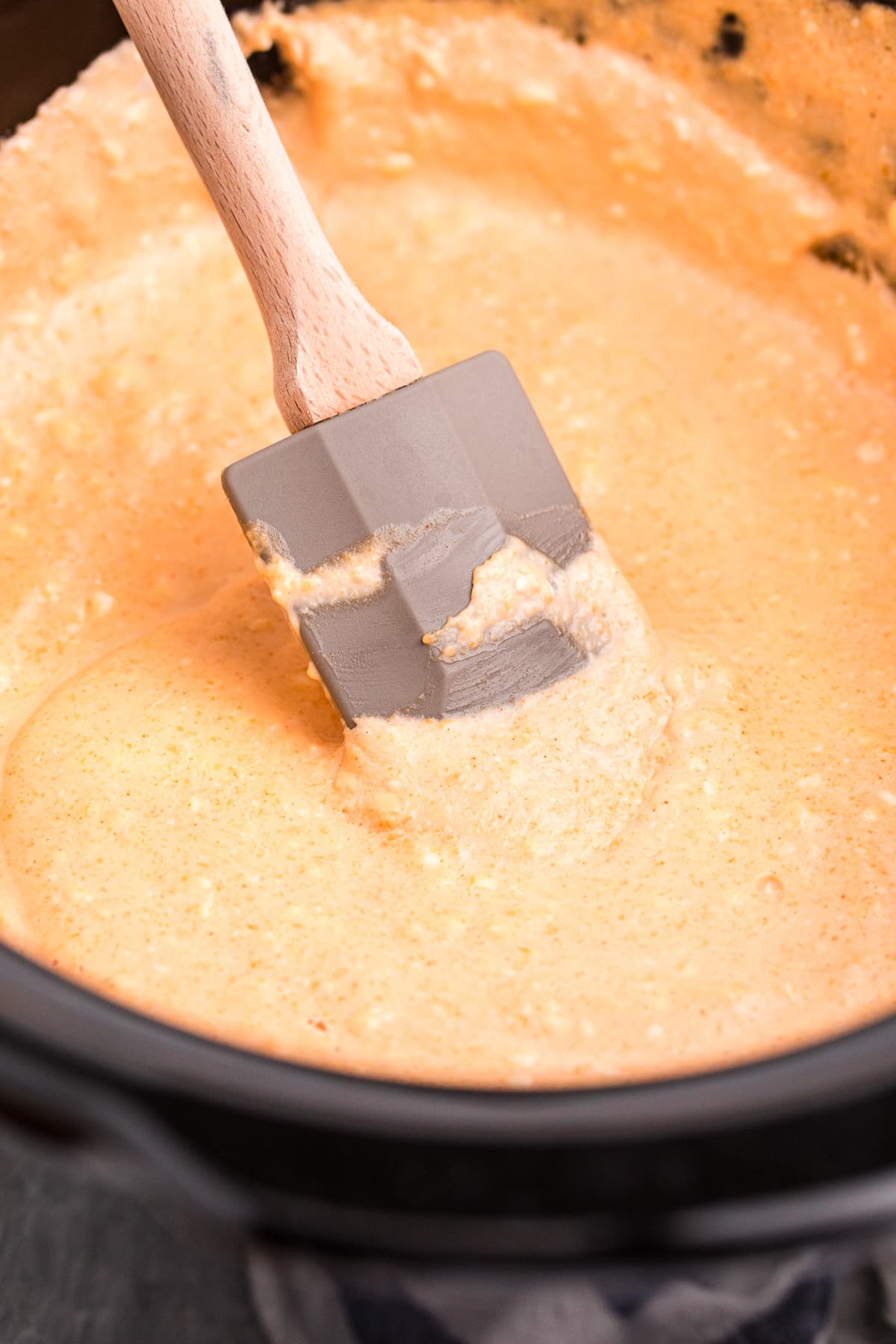 Close up of beef cheese in slow cooker with a spatula.