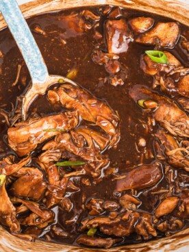 Cooked chicken in bourbon sauce in slow cooker.