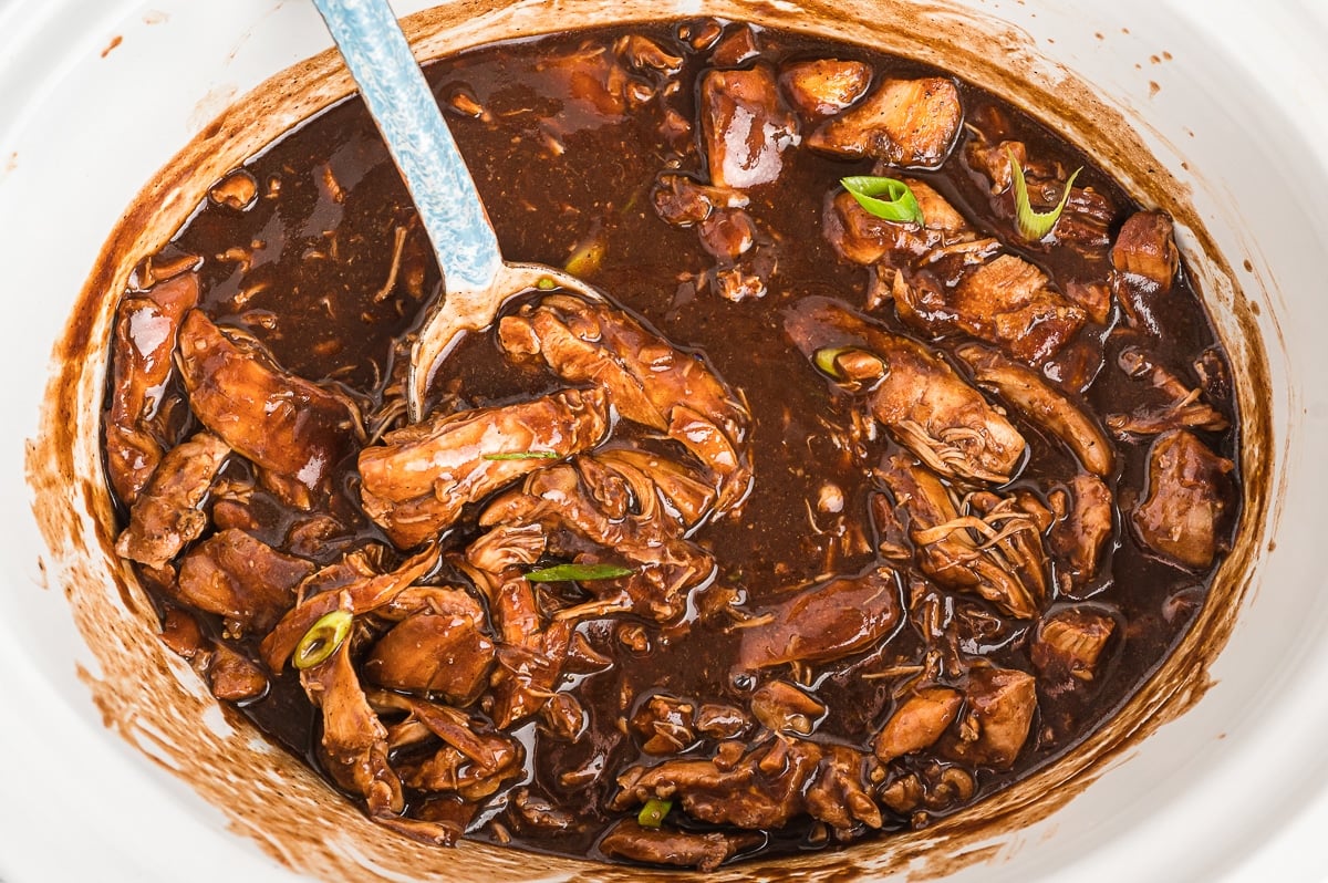 Cooked chicken in bourbon sauce in slow cooker.