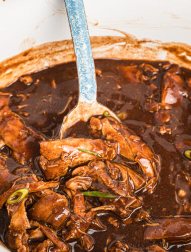 spoon in bourbon chicken in slow cooker.