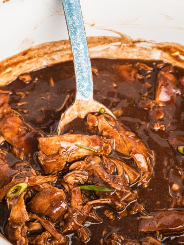 spoon in bourbon chicken in slow cooker.