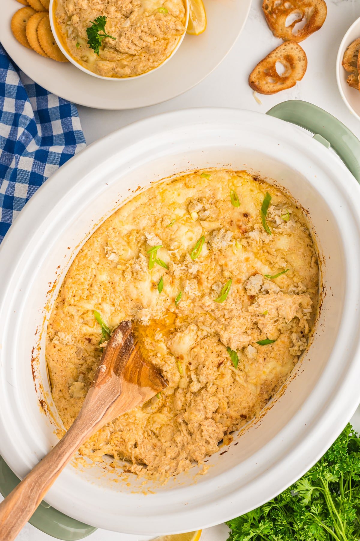 crab dip with a wooden spoon in it.