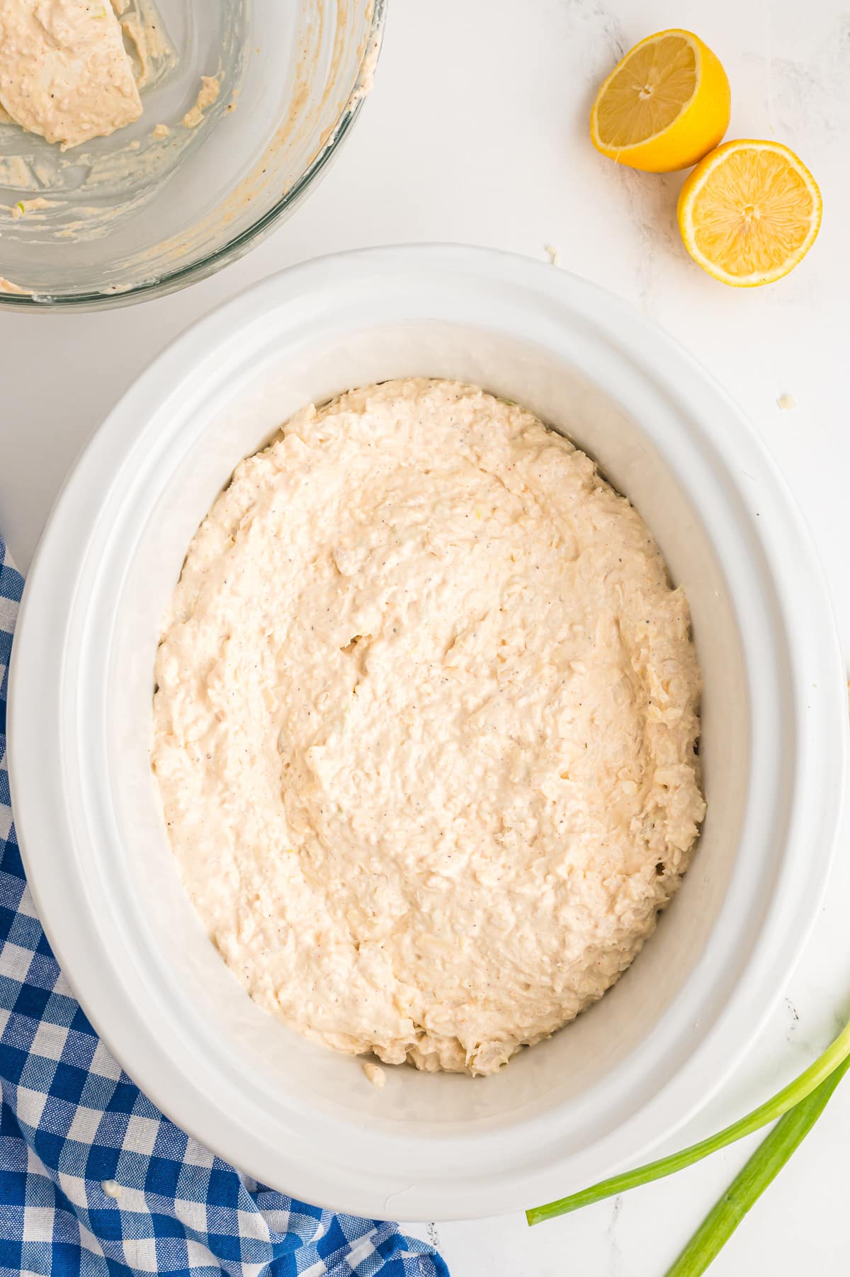 crab dip spread out in the slow cooker.