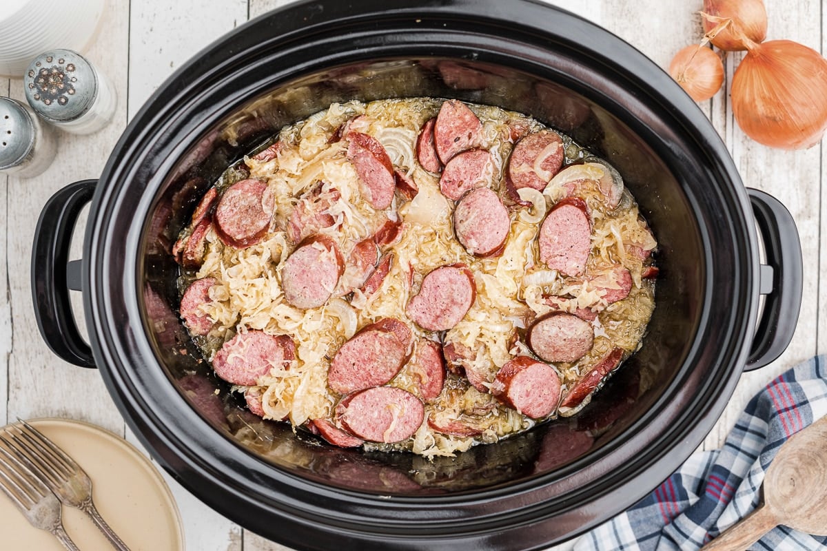 cooked kielbasa, sauerkraut and onion in slow cooker.