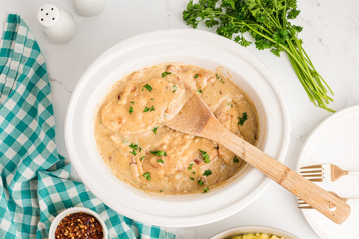 smothered chicken with spoon in it.