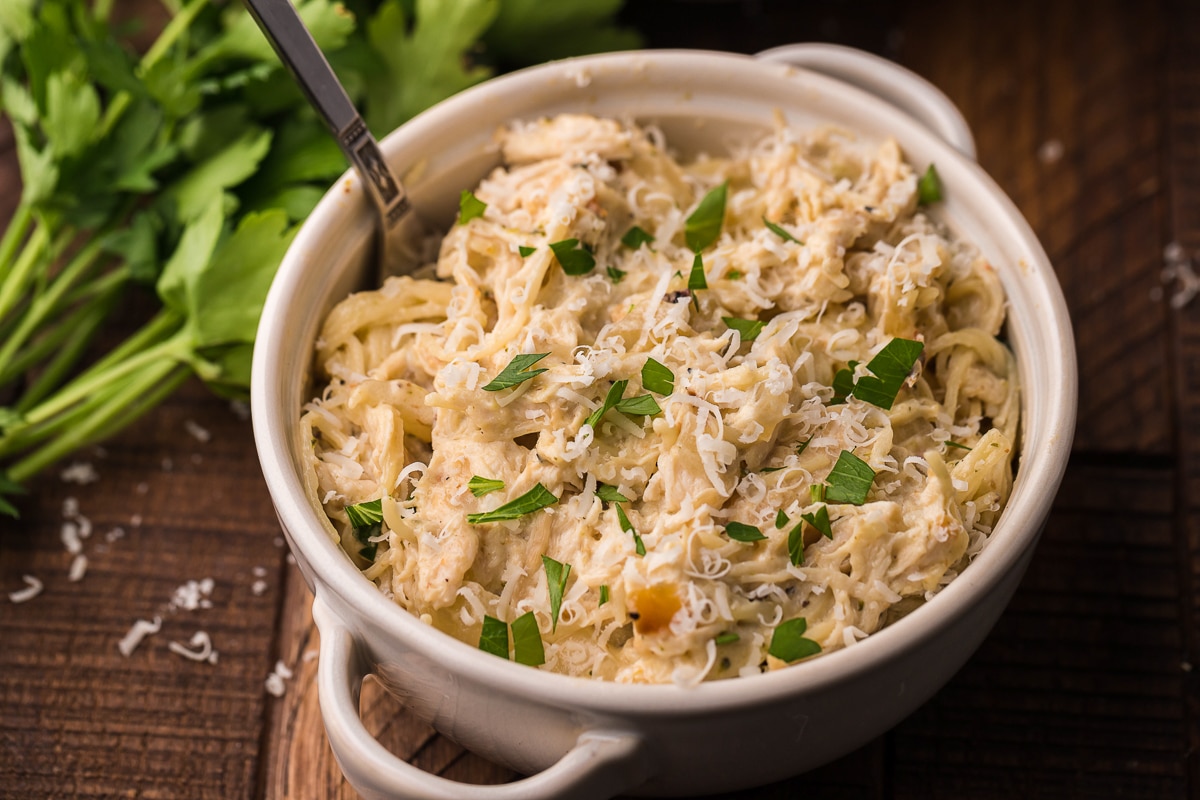 bowl of cooked angel chicken with fork in it.