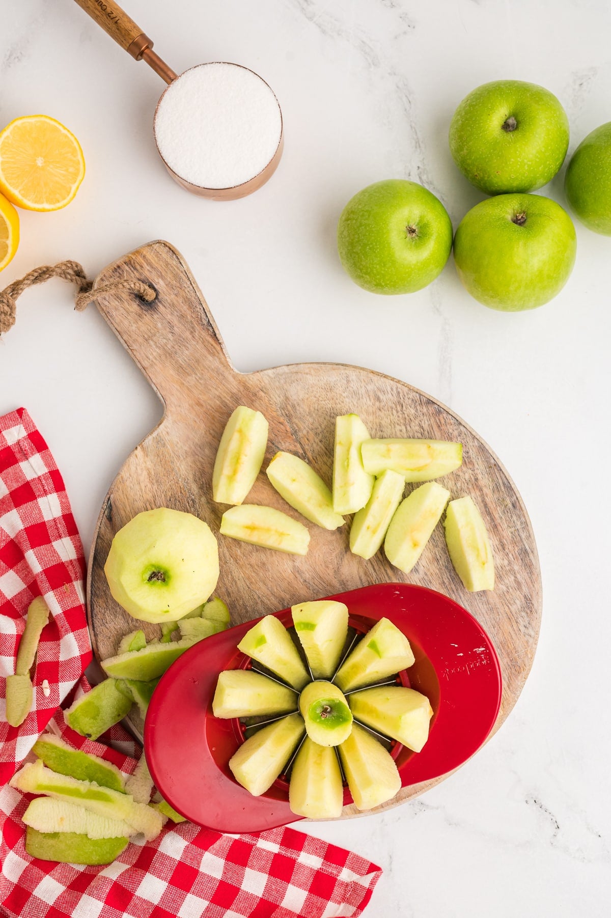 Apples being cored and sliced on a cutting board.
