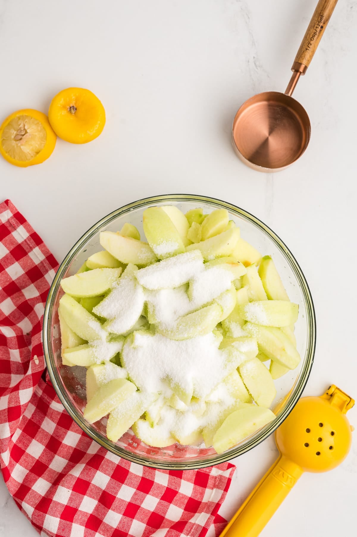 apples with sugar and lemon on them in a bowl.