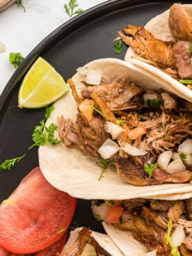 close up of carnitas tacos on a plate.