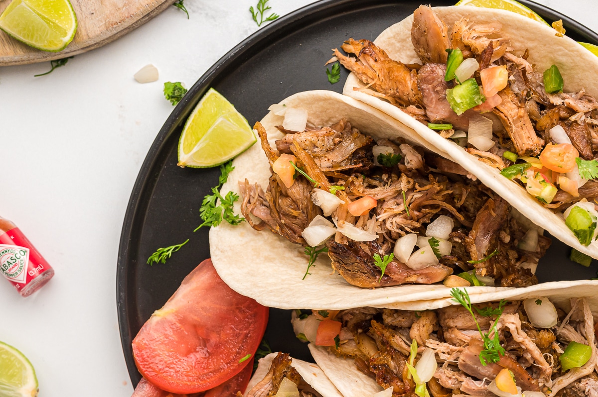 close up of carnitas tacos on a plate.