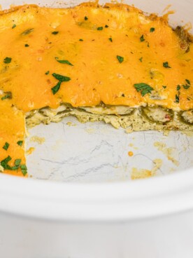 chile relleno casserole with chunk out of it in slow cooker.