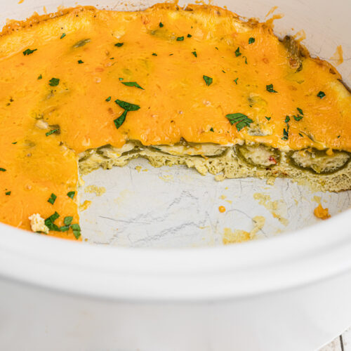 chile relleno casserole with chunk out of it in slow cooker.