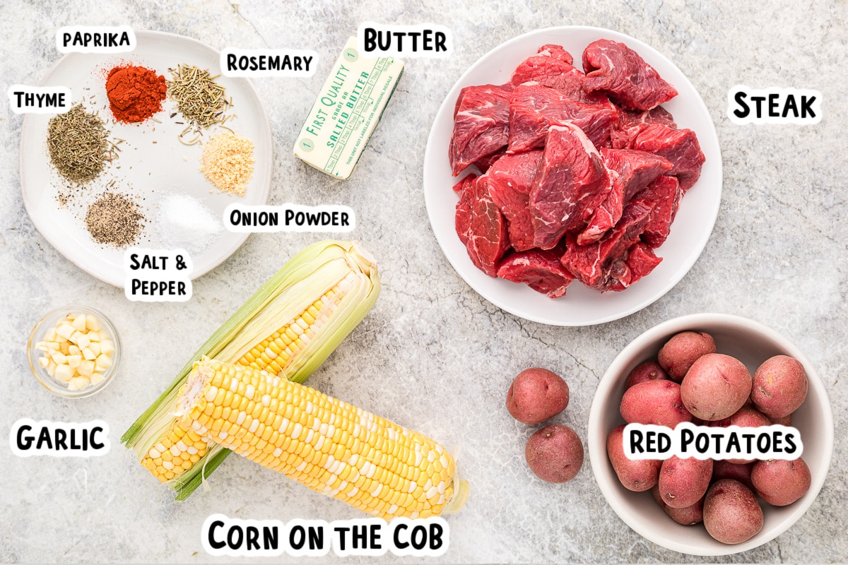 Ingredients for steak, potatoes and corn with garlic butter sauce on table.