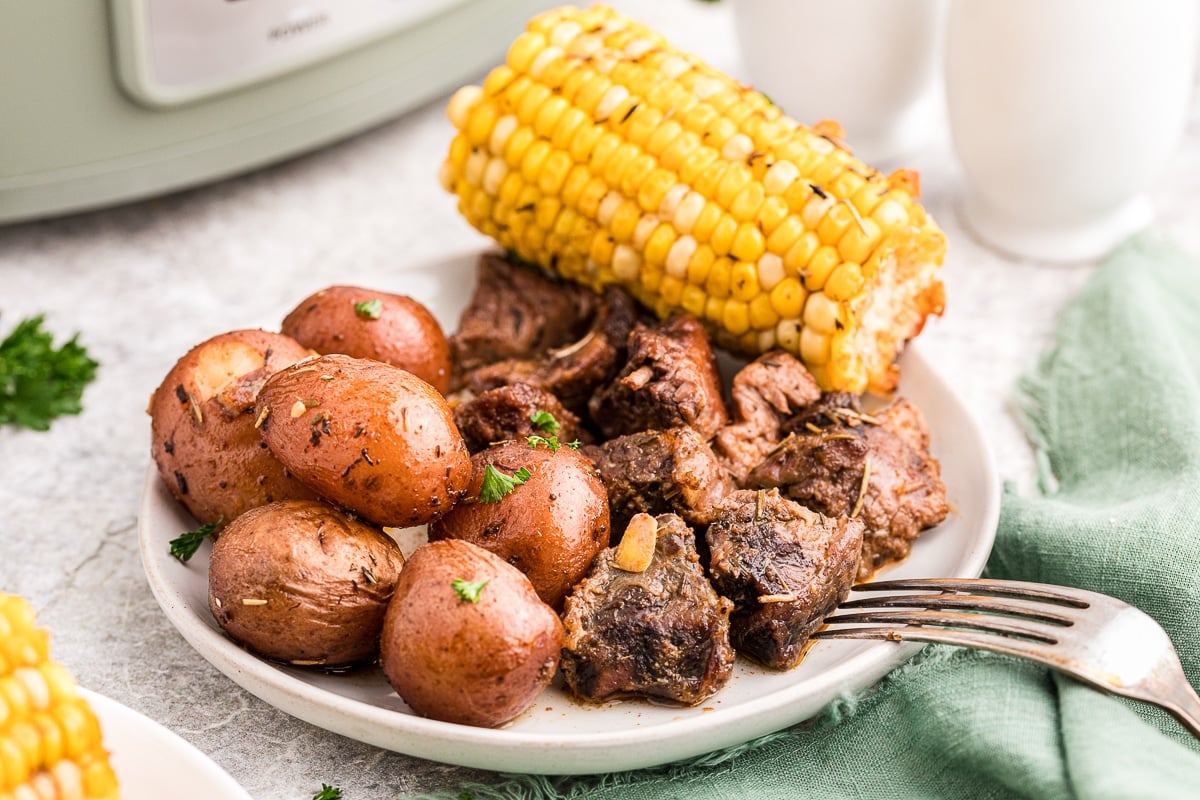 plate with red potatoes, steak and corn on it.