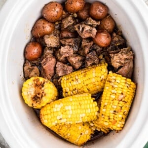 crockpot full of steak potatoes and corn.