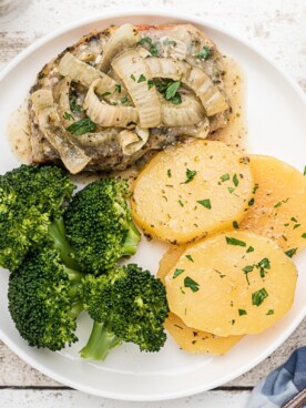 overhead shot of pork chops and potatoes on plate.